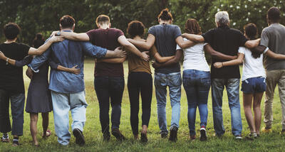 Group of people in a line holding each other up