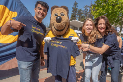 Students in Berkeley Changemakers t-shirts posing with the Oski Bear mascot who is holding up a Berkeley Changemakers t-shirt 
